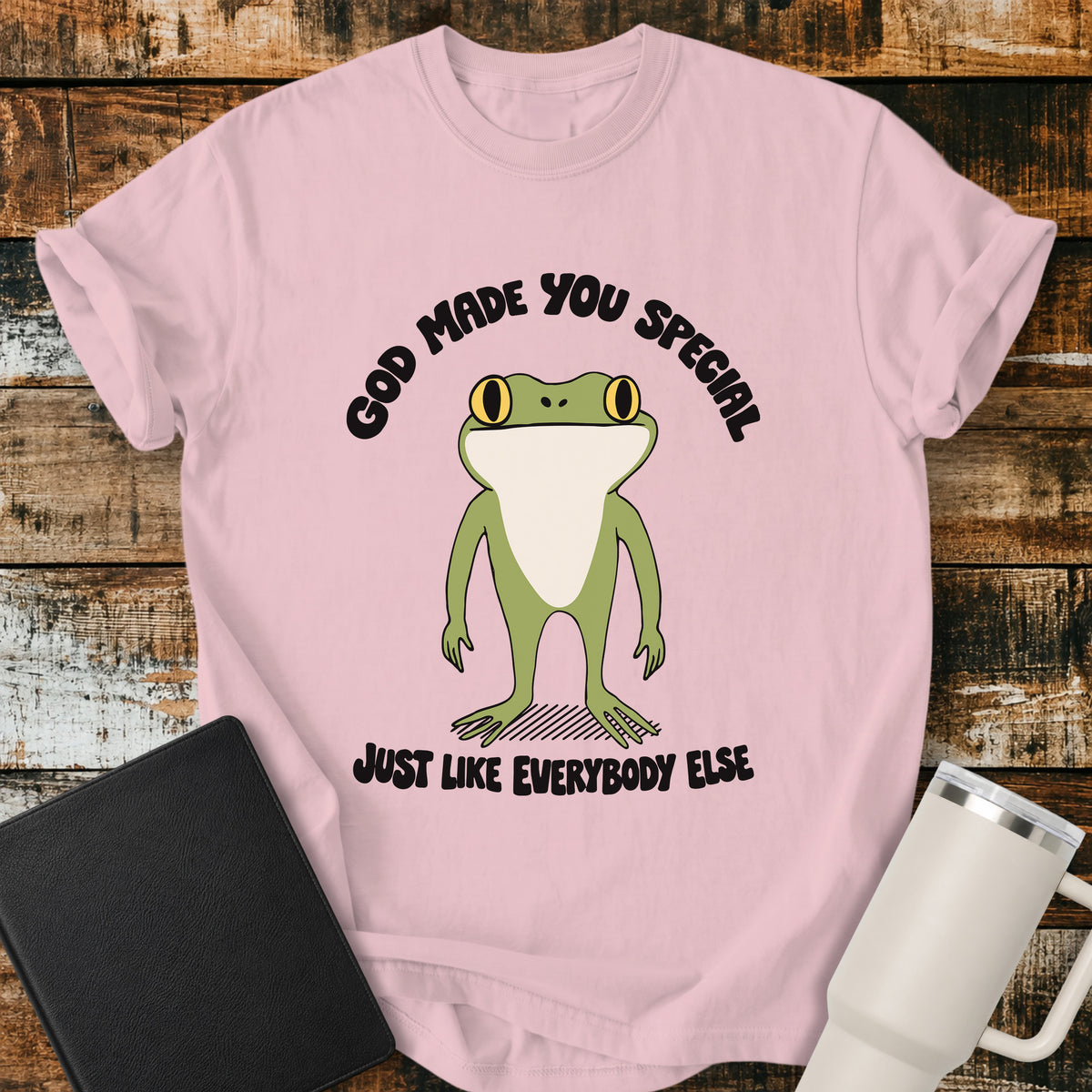 blossom pink Christian T-shirt featuring a retro frog with the words “God Made You Special Just Like Everybody Else” in black lettering.