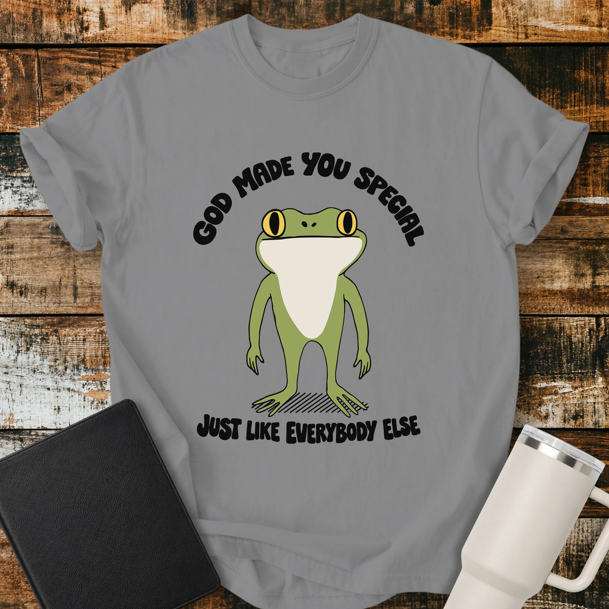 grey Christian T-shirt featuring a retro frog with the words “God Made You Special Just Like Everybody Else” in black lettering.