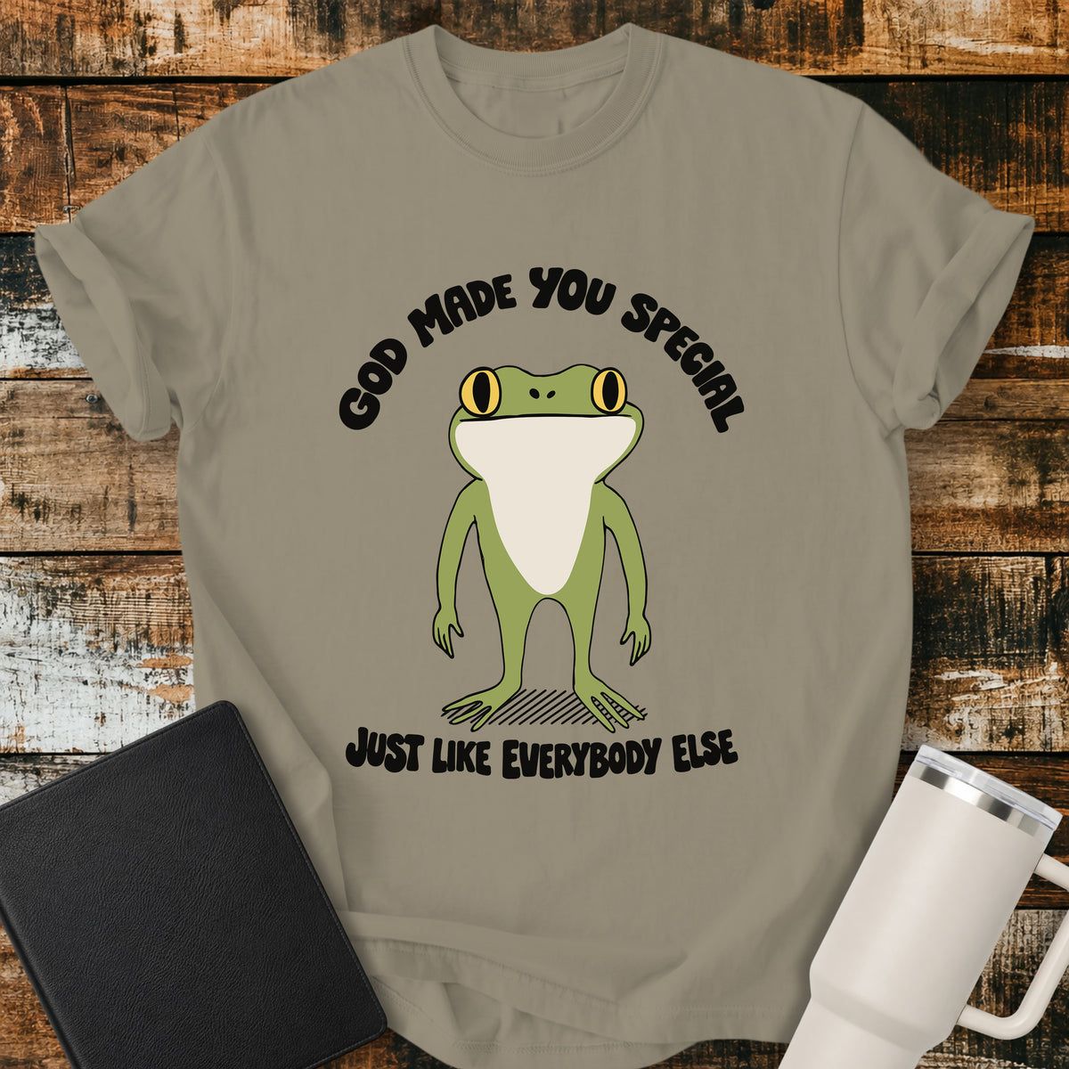 sandstone Christian T-shirt featuring a retro frog with the words “God Made You Special Just Like Everybody Else” in black lettering.