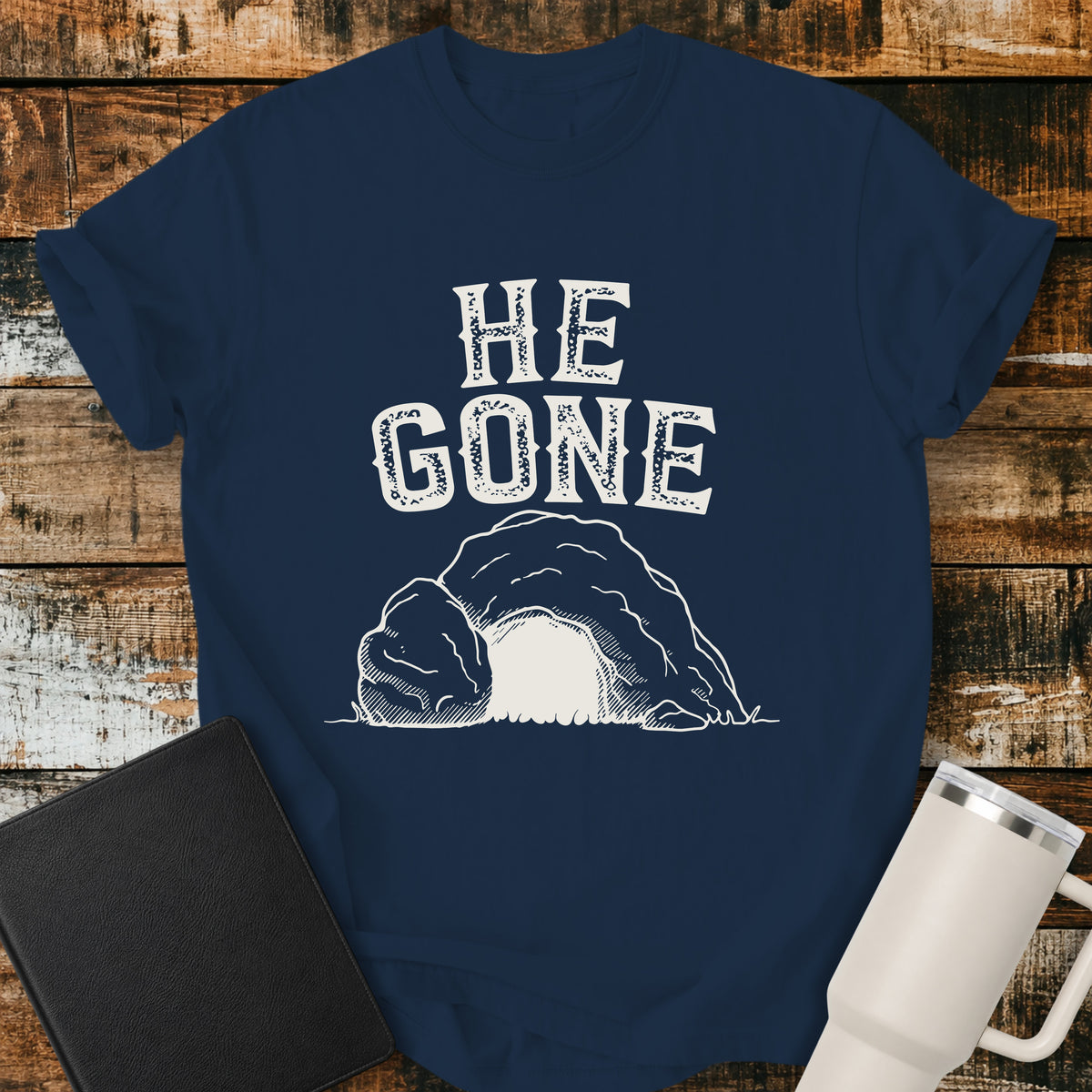 true navy blue Christian T-shirt featuring an empty tomb illustration with the words “He Gone” in distressed cream lettering.