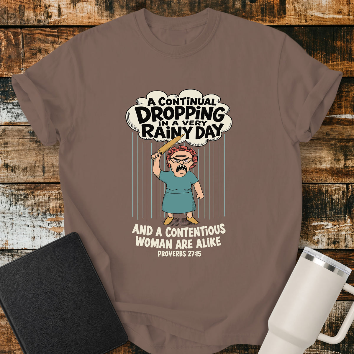 espresso brown Christian t-shirt featuring a humorous illustration inspired by Proverbs 27:15, with the verse “A continual dropping in a very rainy day and a contentious woman are alike.”