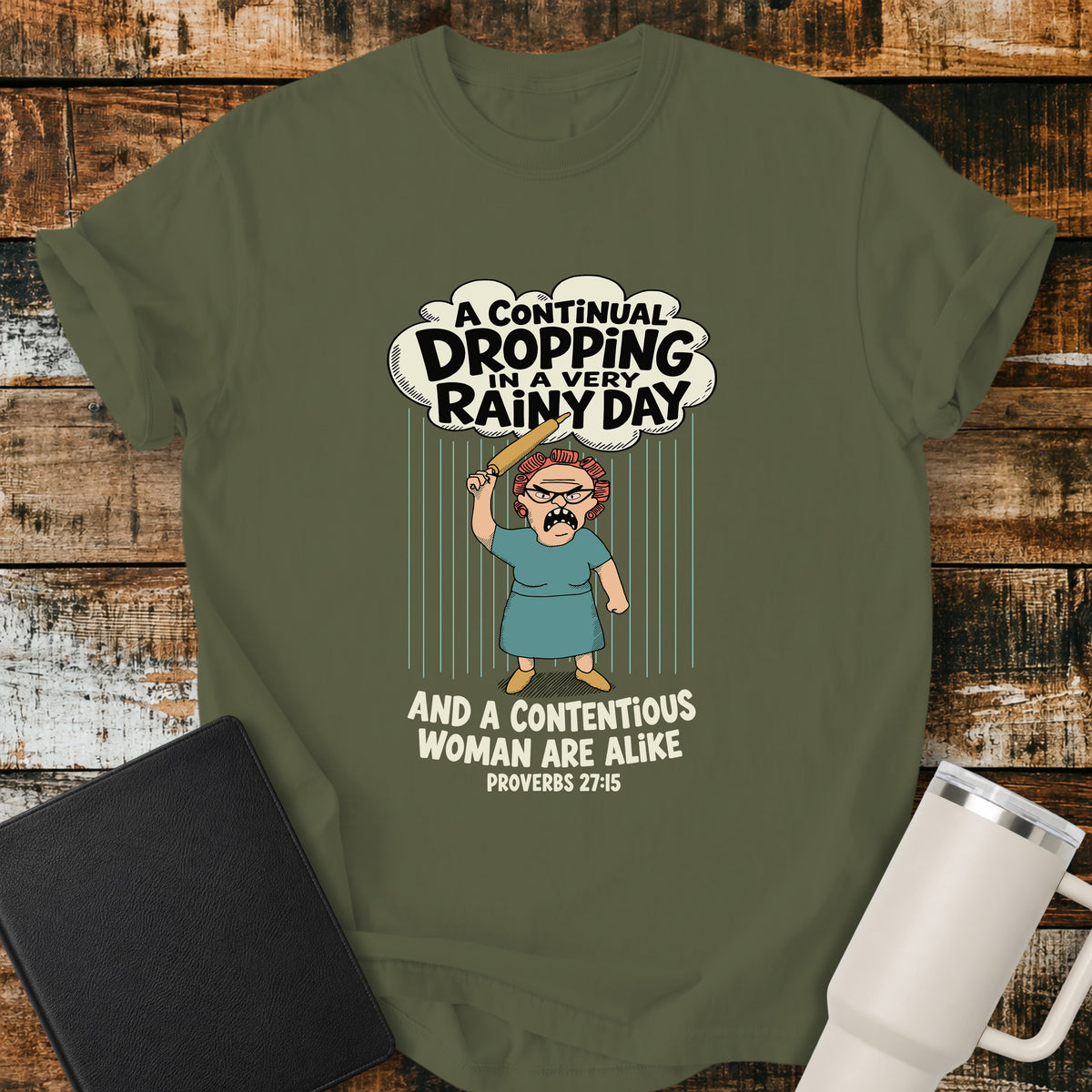 hemp green Christian t-shirt featuring a humorous illustration inspired by Proverbs 27:15, with the verse “A continual dropping in a very rainy day and a contentious woman are alike.”