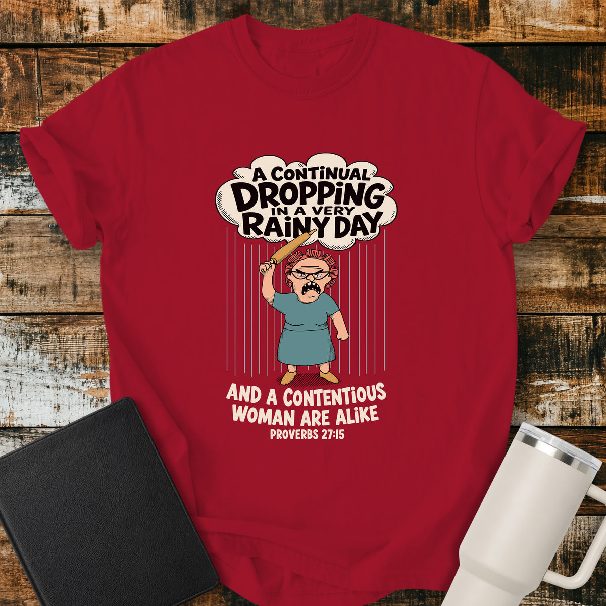 red Christian t-shirt featuring a humorous illustration inspired by Proverbs 27:15, with the verse “A continual dropping in a very rainy day and a contentious woman are alike.”