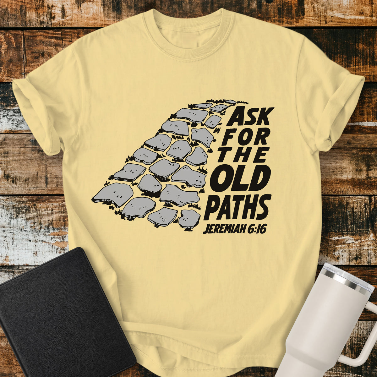 butter yellow Christian t-shirt featuring a vintage stone pathway illustration with bold retro lettering reading “Ask for the Old Paths” and Jeremiah 6:16.