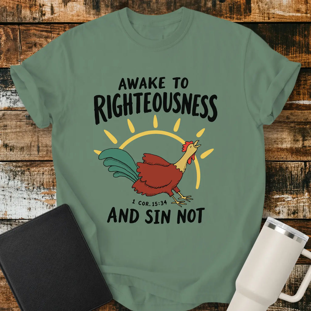 light green graphic T-shirt mockup featuring a rooster illustration with a rising sun and the phrase “Awake to Righteousness and Sin Not” with a 1 Corinthians 15:34 reference, styled with a black Bible and white tumbler on a rustic wood background.
