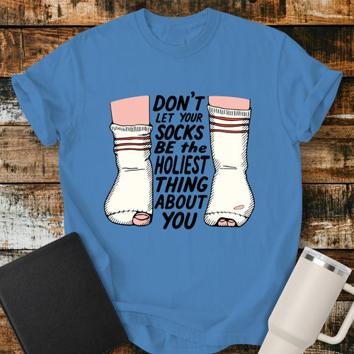 royal caribe blue Christian T-shirt featuring worn, holey socks with the humorous phrase “Don’t Let Your Socks Be the Holiest Thing About You” in black lettering