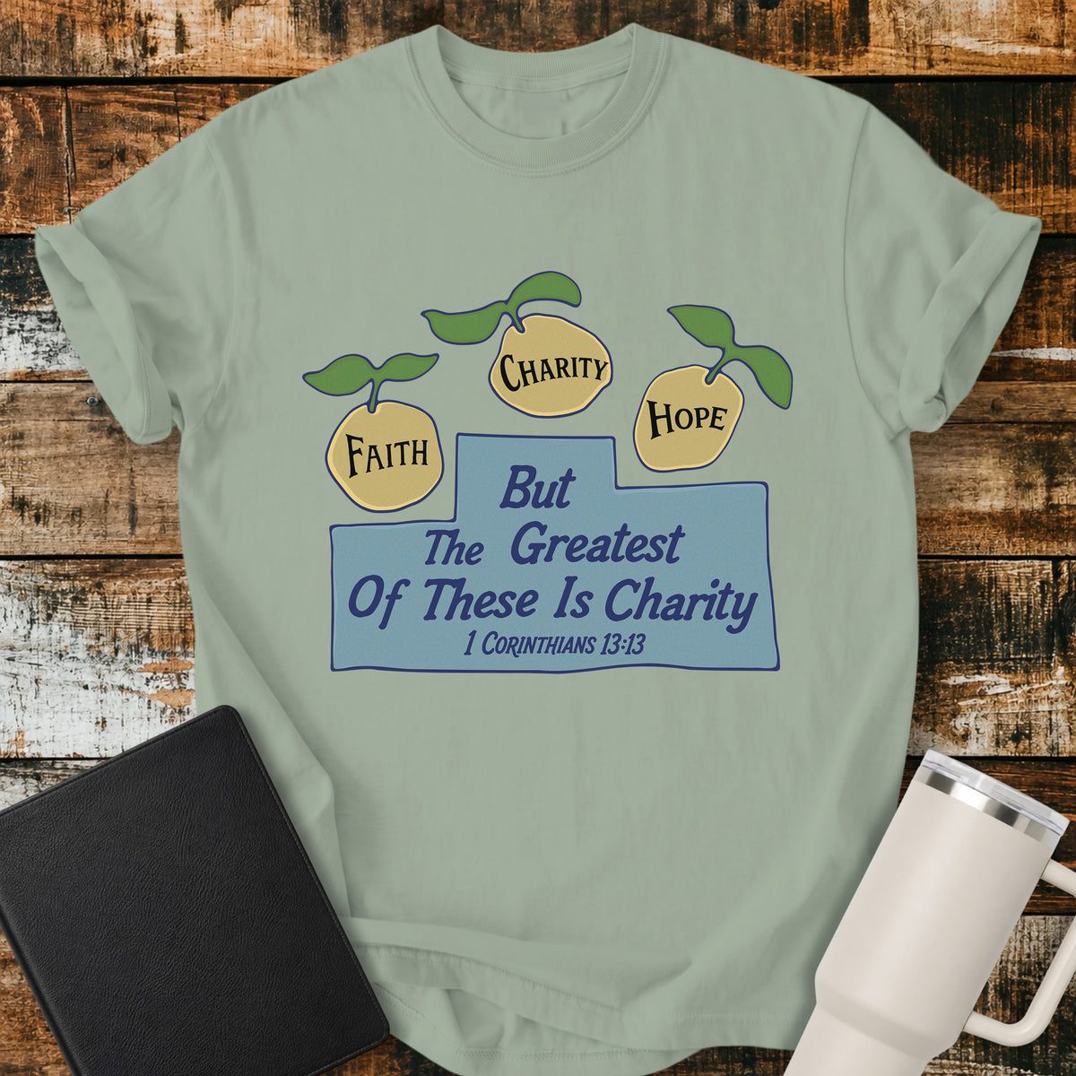bay green Christian t-shirt featuring three lemons labeled “Faith,” “Charity,” and “Hope,” with the words “But the Greatest of These Is Charity” and 1 Corinthians 13:13. A cheerful, vintage-inspired biblical design illustrating faith, hope, and charity.