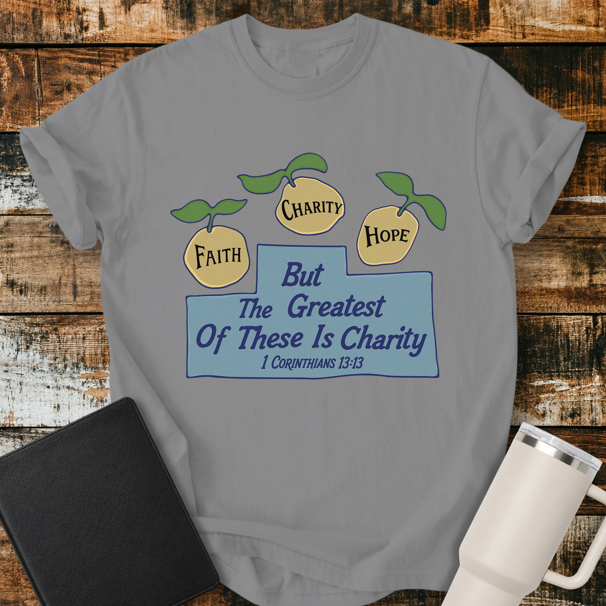 grey Christian t-shirt featuring three lemons labeled “Faith,” “Charity,” and “Hope,” with the words “But the Greatest of These Is Charity” and 1 Corinthians 13:13. A cheerful, vintage-inspired biblical design illustrating faith, hope, and charity.