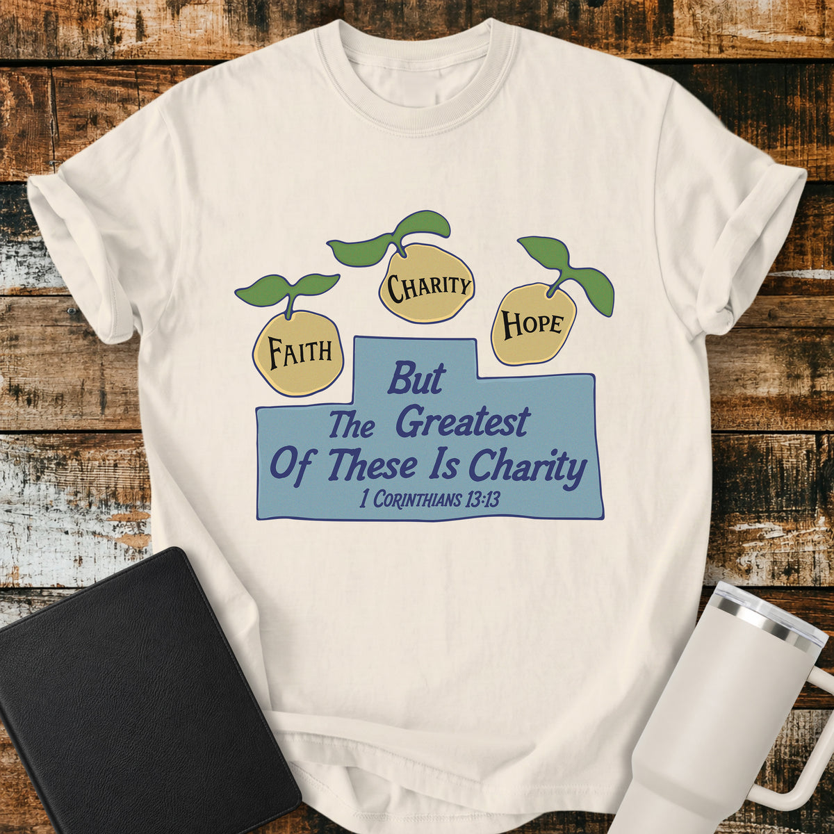 ivory Christian t-shirt featuring three lemons labeled “Faith,” “Charity,” and “Hope,” with the words “But the Greatest of These Is Charity” and 1 Corinthians 13:13. A cheerful, vintage-inspired biblical design illustrating faith, hope, and charity.