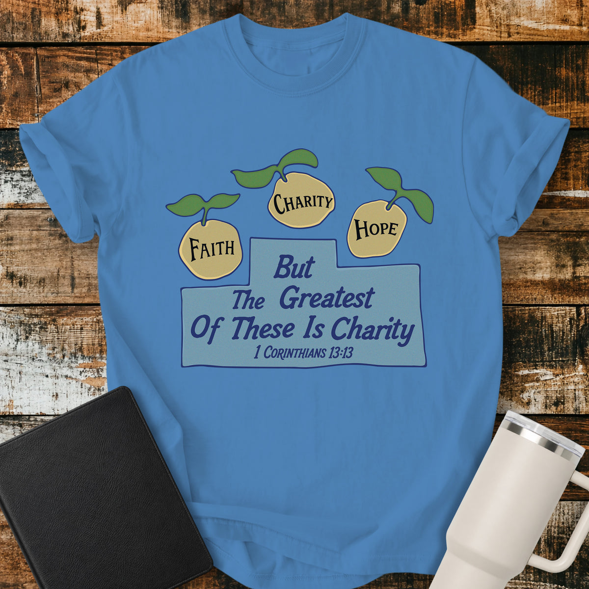 Royal Caribe blue Christian t-shirt featuring three lemons labeled “Faith,” “Charity,” and “Hope,” with the words “But the Greatest of These Is Charity” and 1 Corinthians 13:13. A cheerful, vintage-inspired biblical design illustrating faith, hope, and charity.