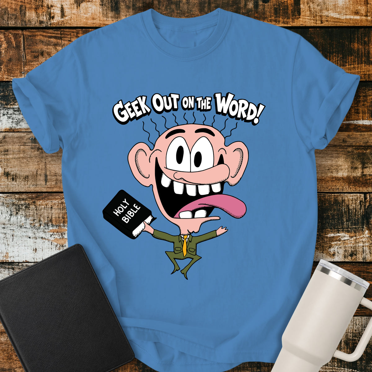 Royal caribe blue Christian T-shirt featuring a playful retro cartoon character holding a Holy Bible beneath the bold phrase, “GEEK OUT ON THE WORD!”—a fun faith-based design for Bible lovers.