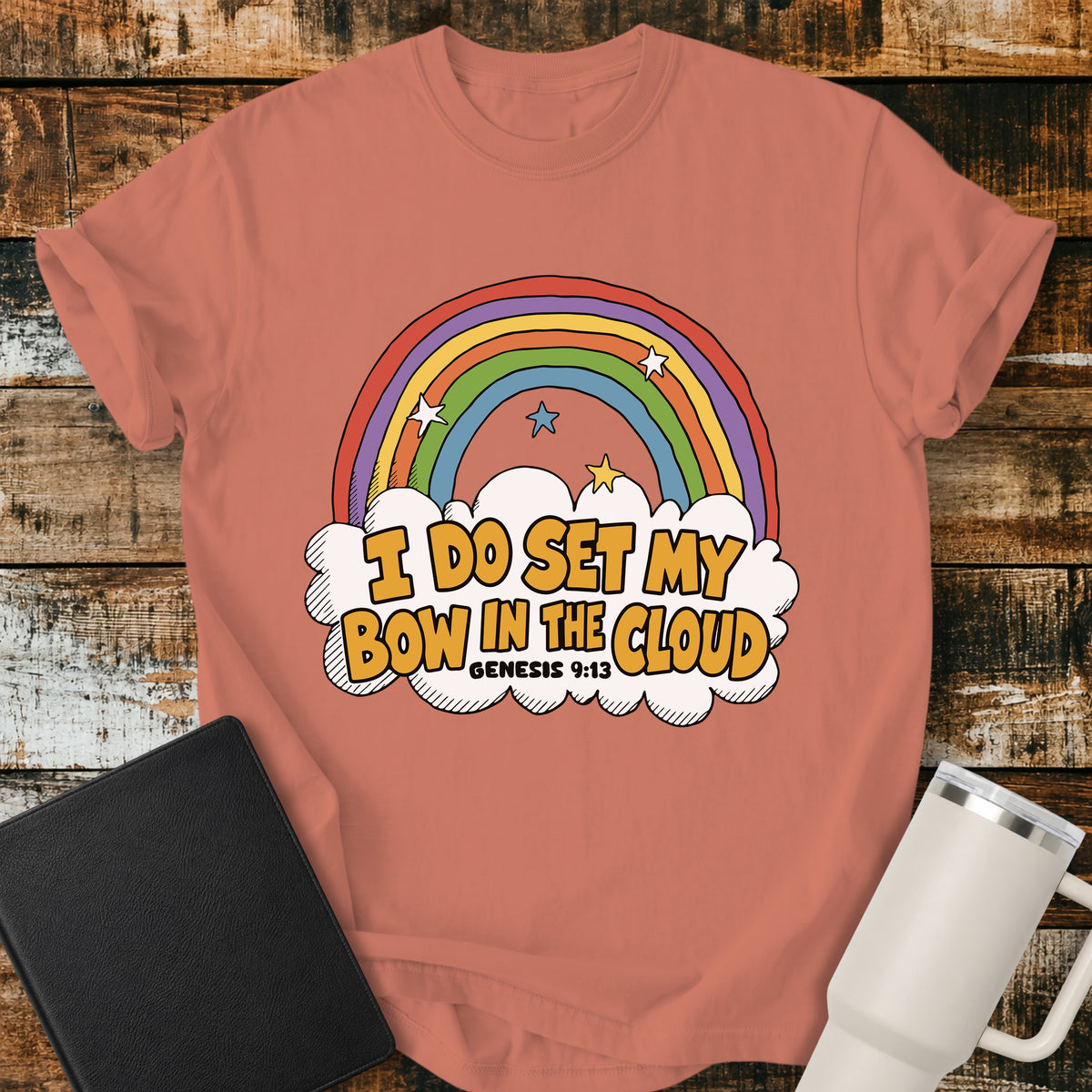 Terracotta Christian T-shirt featuring a colorful retro rainbow and cloud illustration with the Scripture phrase, “I DO SET MY BOW IN THE CLOUD,” and the Bible reference “GENESIS 9:13.”