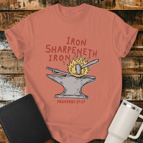 terracotta Christian T-shirt featuring an anvil, hammer, and fire with the words “Iron Sharpeneth Iron” and “Proverbs 27:17.”