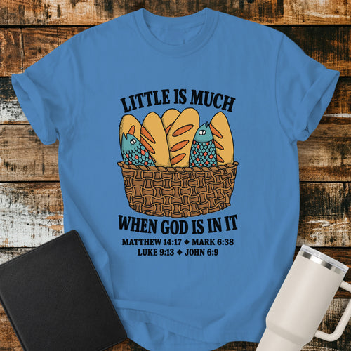 royal caribe blue Christian t-shirt featuring a vintage-style basket filled with five loaves and two fish, with bold lettering reading “Little Is Much When God Is in It” and references to Matthew 14:17, Mark 6:38, Luke 9:13, and John 6:9.