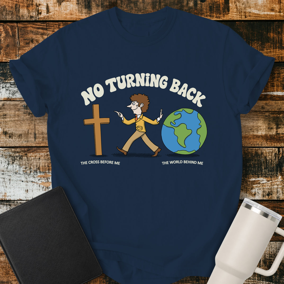 true navy blue Christian t-shirt featuring a retro illustration of a man walking toward the cross and leaving the world behind, with the message “No Turning Back” and the phrases “The Cross Before Me” and “The World Behind Me.”