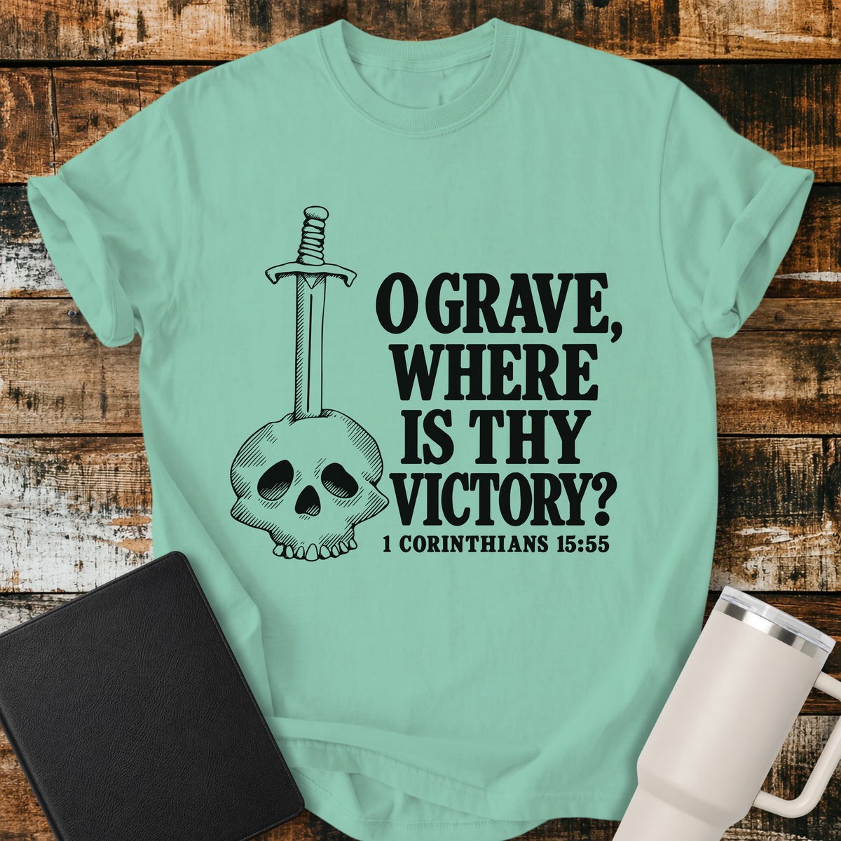 island reef green Christian T-shirt featuring a skull pierced by a sword beside the bold Scripture text, “O GRAVE, WHERE IS THY VICTORY?” with the Bible reference “1 CORINTHIANS 15:55.”