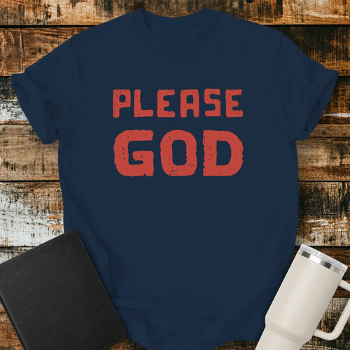 True Navy T-shirt mockup featuring the simple phrase “PLEASE GOD” in large distressed red block lettering. The minimalist design is centered on the shirt, creating a bold faith-inspired statement. The shirt is displayed on a rustic wood plank background beside a black Bible and a white insulated tumbler.