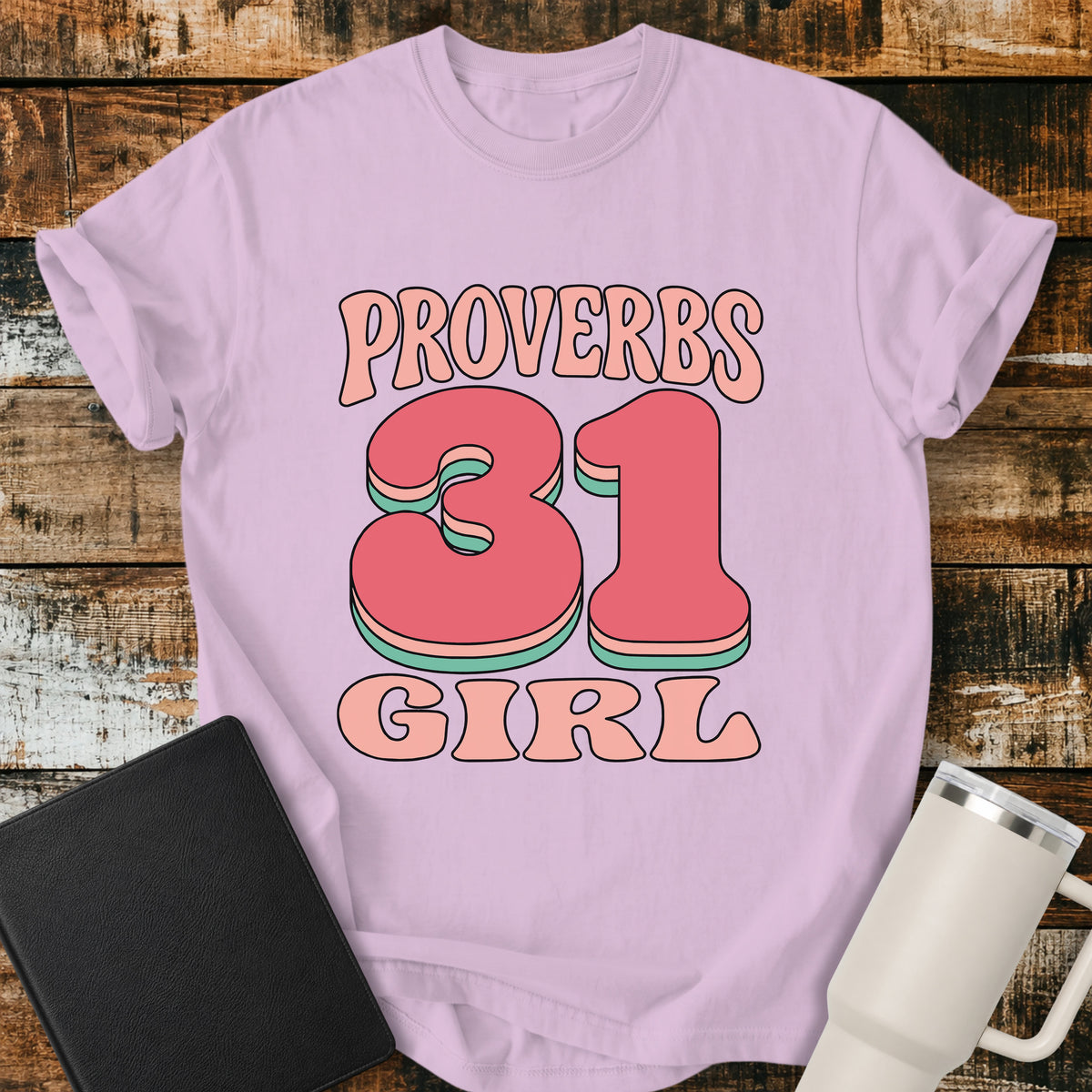 Orchid purple Christian T-shirt featuring a bold retro “PROVERBS 31 GIRL” design in playful pink, coral, and mint lettering with a fun vintage-inspired look.