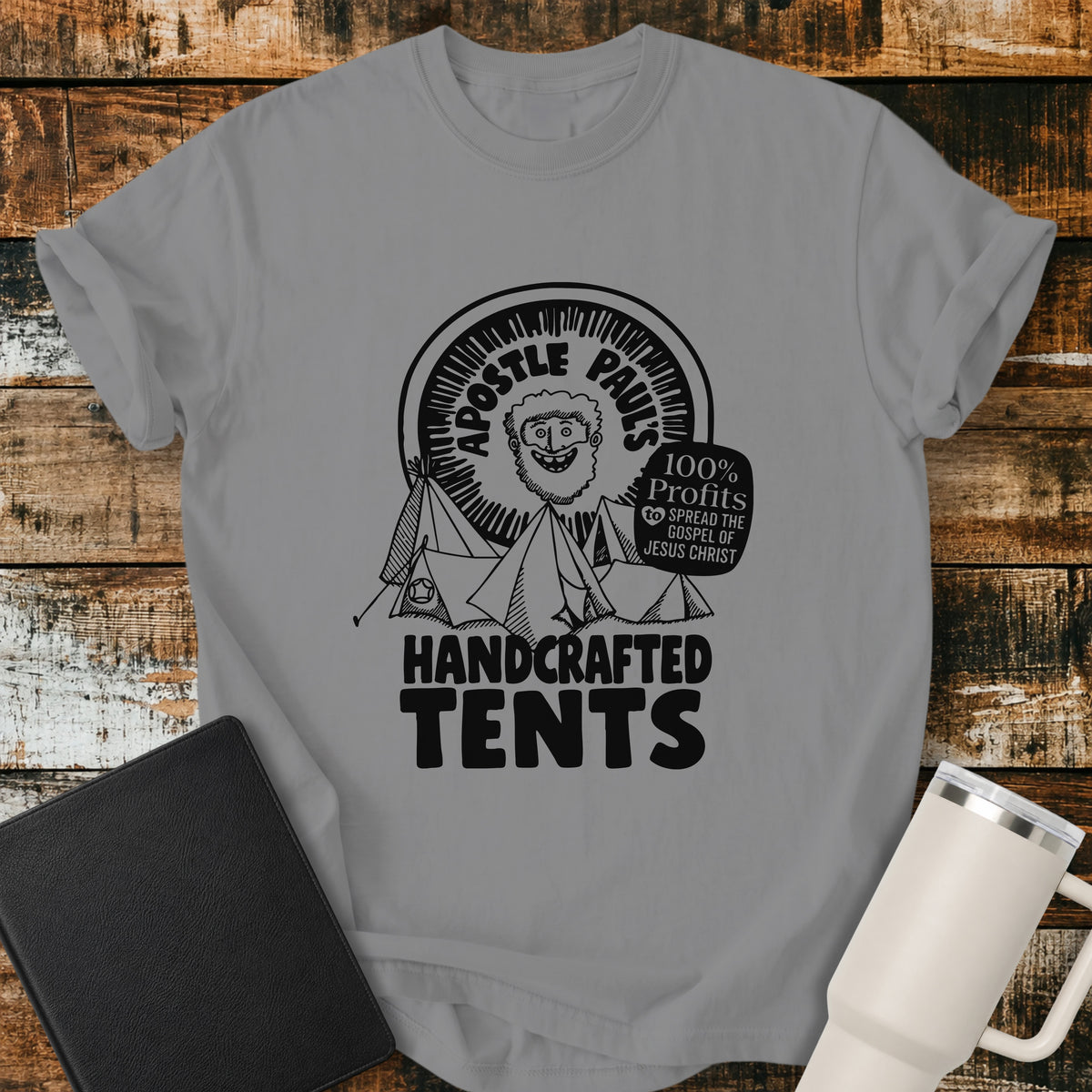 grey Christian T-shirt featuring Apostle Paul with handcrafted tents and the words “100% Profits to Spread the Gospel of Jesus Christ.”