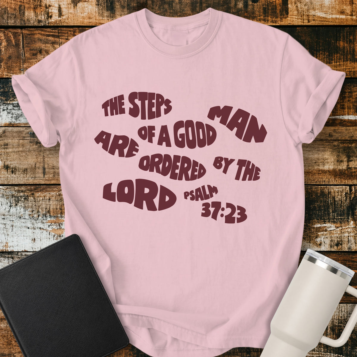 blossom pink Christian t-shirt featuring bold retro typography with Psalm 37:23: “The steps of a good man are ordered by the LORD.”