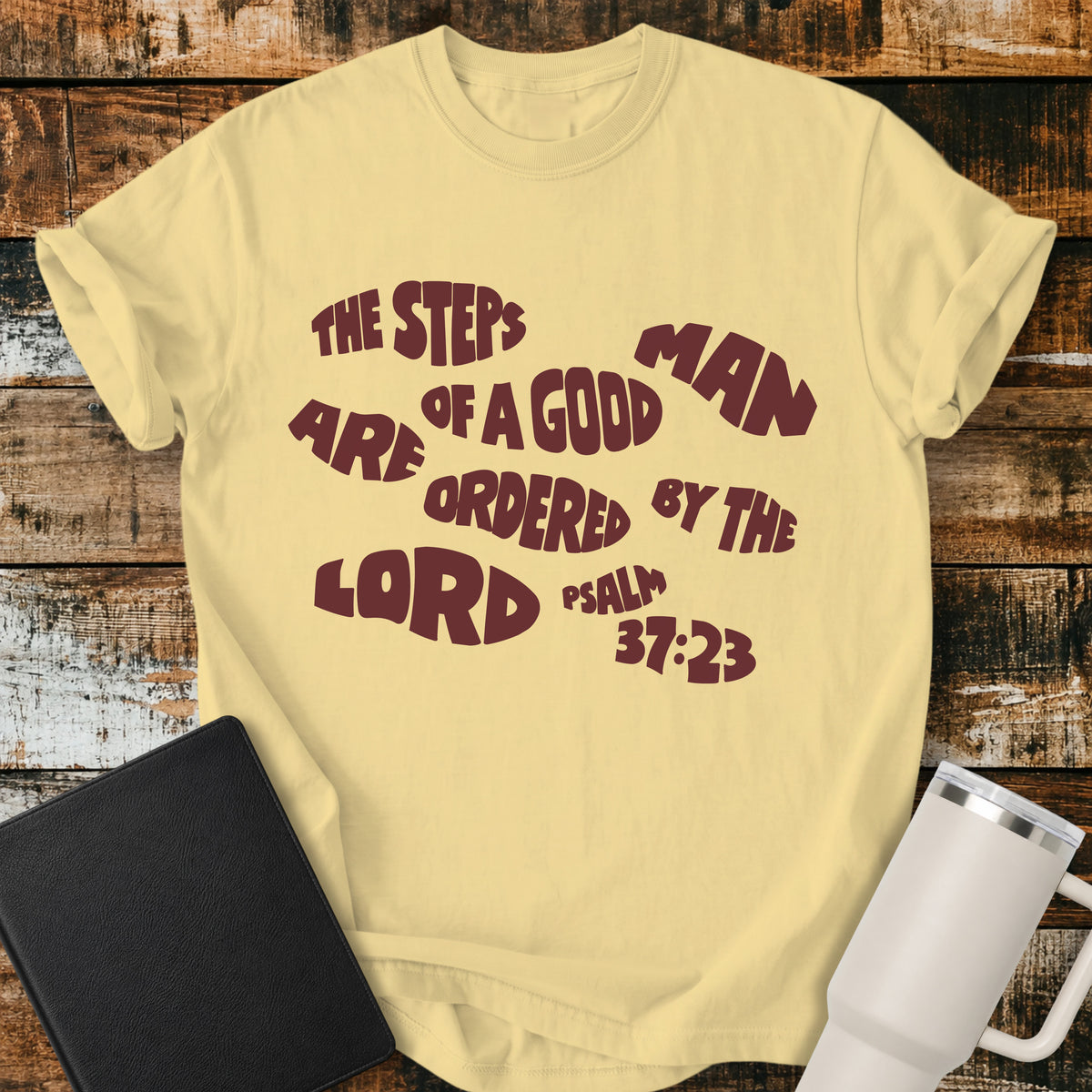 butter yellow Christian t-shirt featuring bold retro typography with Psalm 37:23: “The steps of a good man are ordered by the LORD.”
