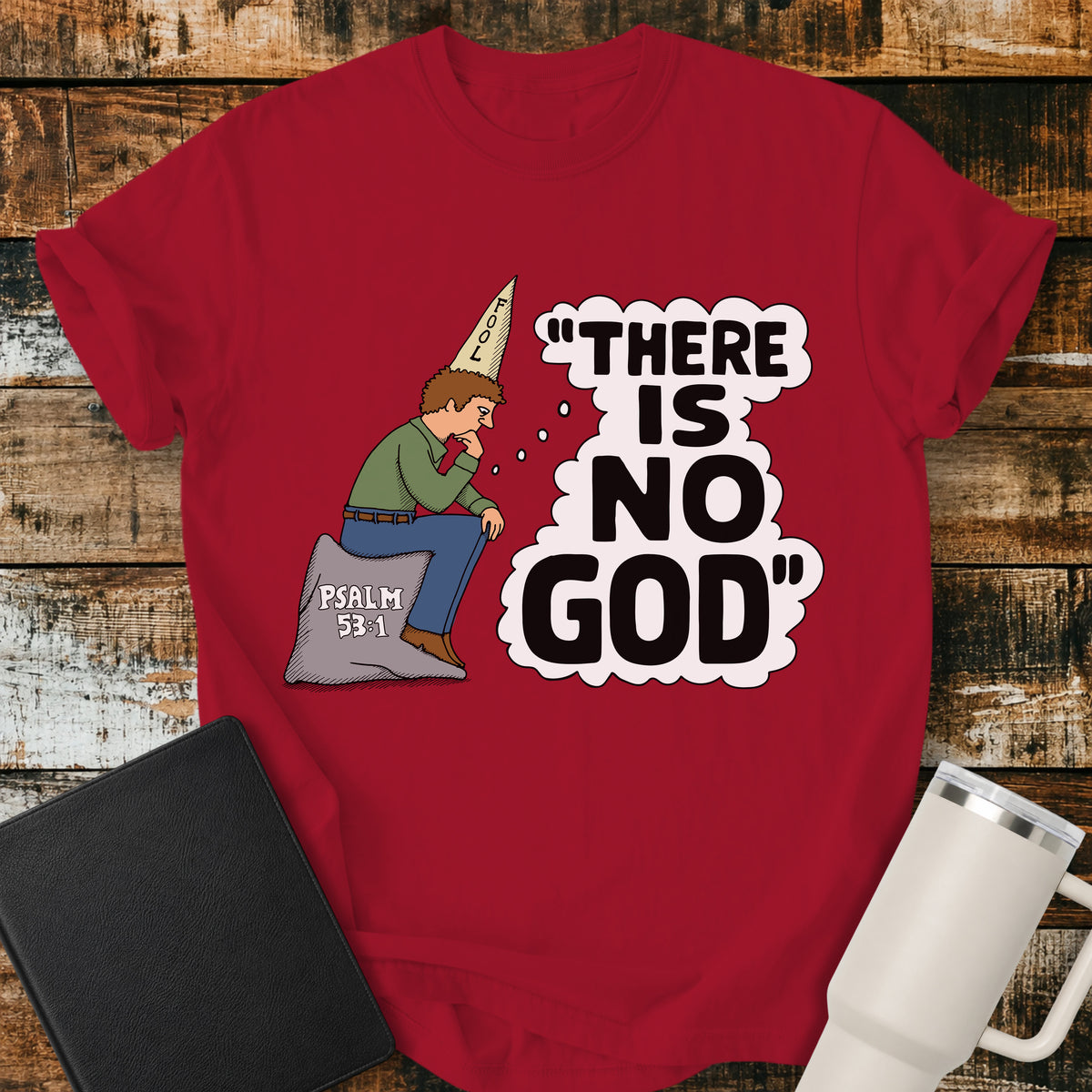 red Christian t-shirt featuring a humorous illustration of a man in a “FOOL” cap pondering the statement “There Is No God,” inspired by Psalm 53:1.