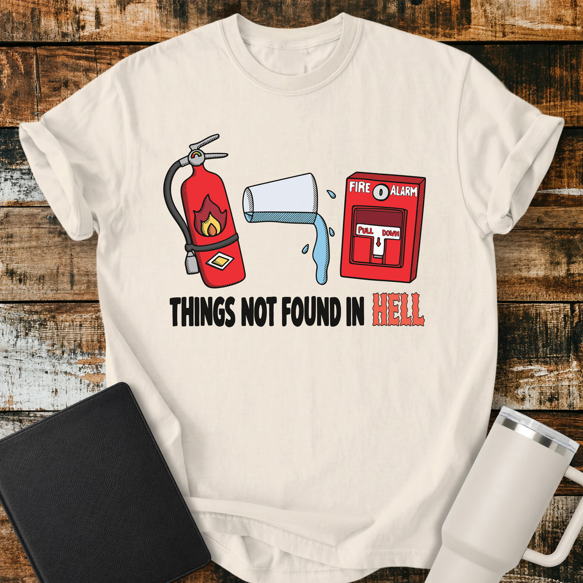 Ivory Christian T-shirt featuring a fire extinguisher, a glass of water, and a fire alarm above the bold phrase “THINGS NOT FOUND IN HELL,” creating a clever, amusing faith-based design with a retro illustrated style.