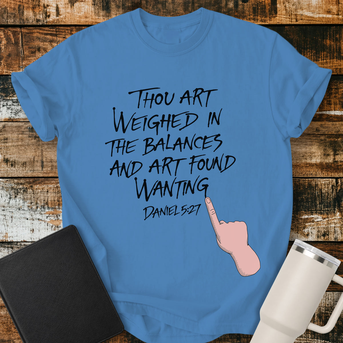 royal caribe blue Christian t-shirt featuring hand-lettered typography with Daniel 5:27: “Thou art weighed in the balances, and art found wanting,” paired with a pointing-hand illustration.